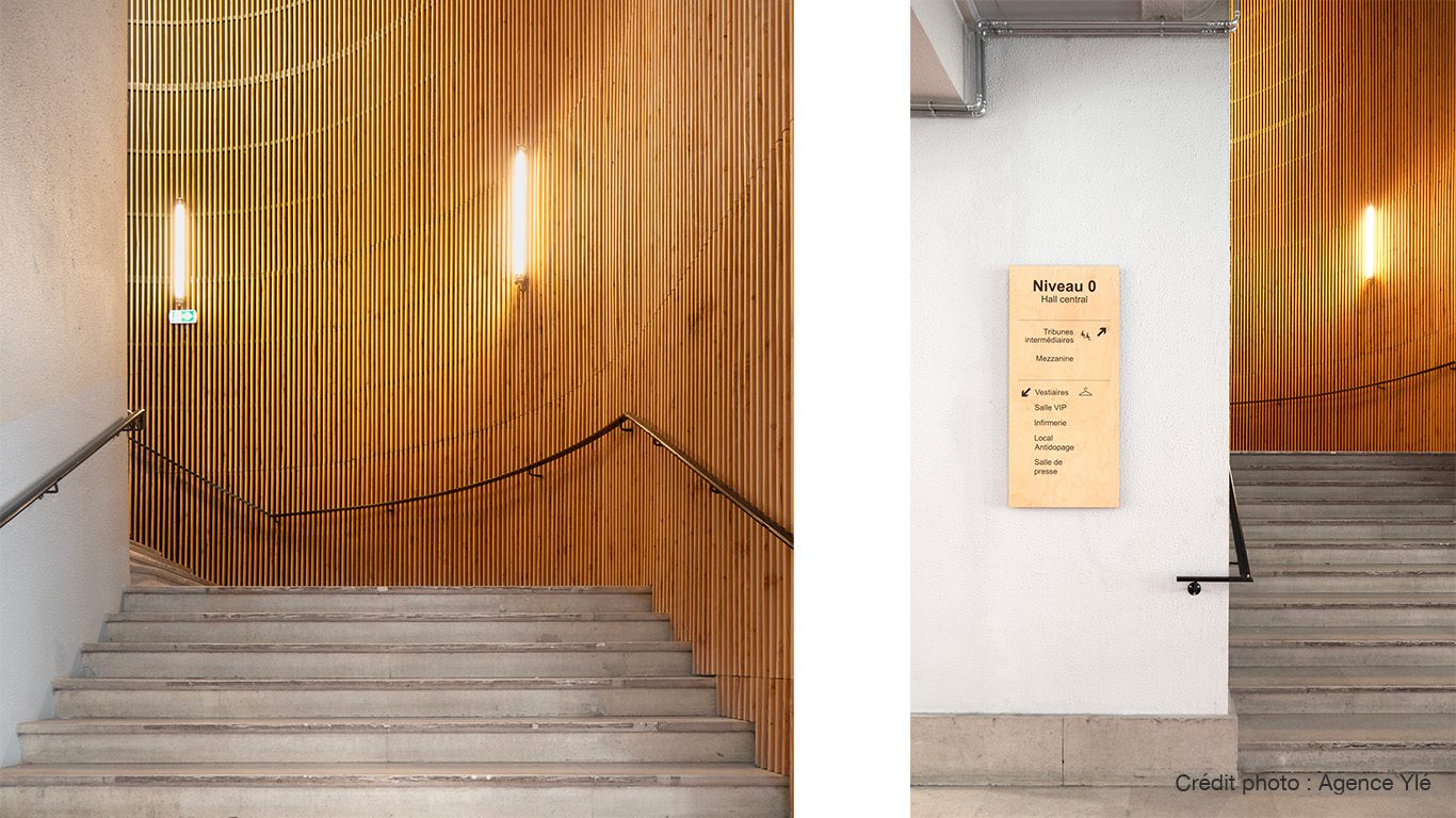 Escalier en pierre avec mains courantes noires et panneau Niveau 0 Hall central au Stade Coubertin à Paris